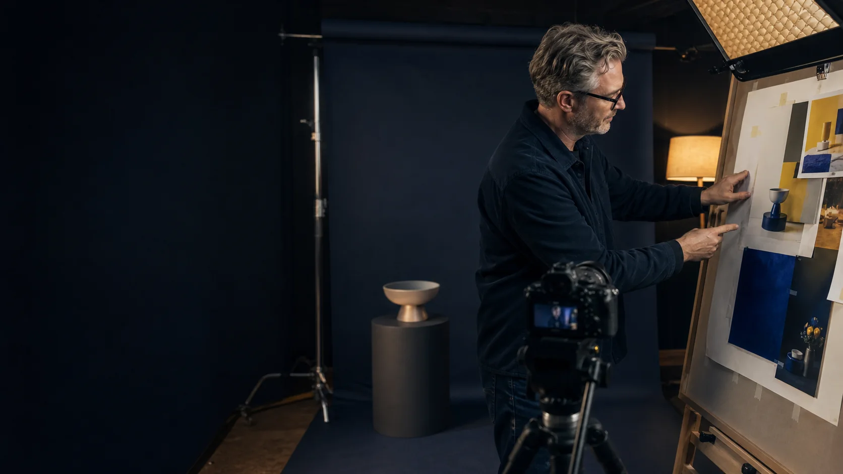 A creative director preparing campaign artwork in a professional studio